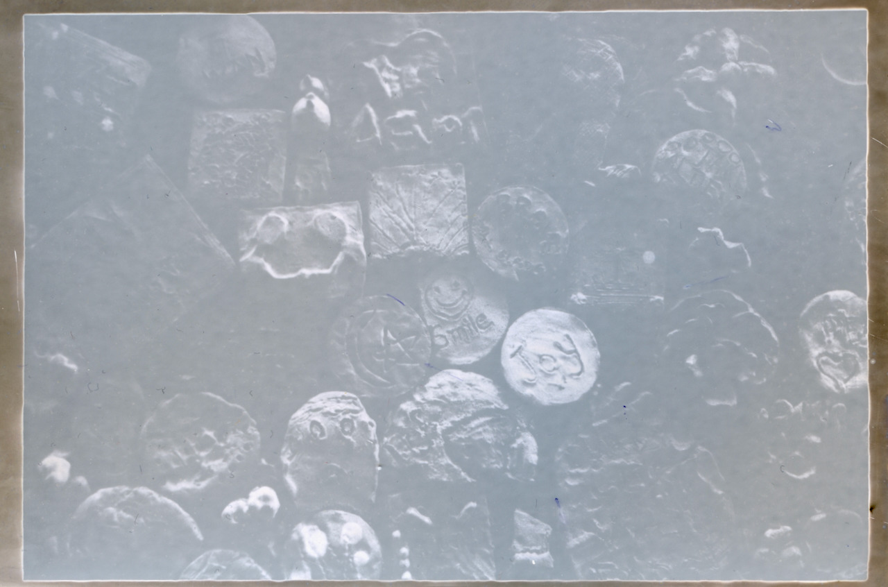 The same clay tokens on RA-4 paper developed in black and white chemistry, pale blue with a gold border